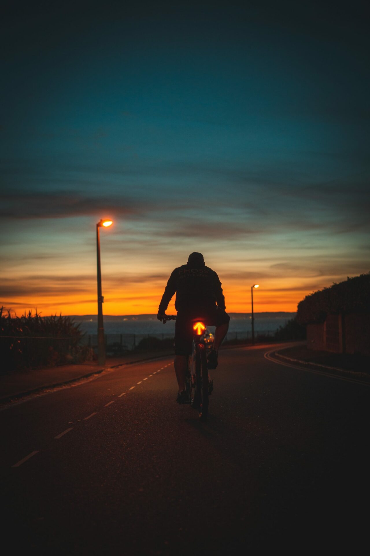 Cyclist using the Illuminated Signalling Tailbag with bright LED directional indicators on his bike in low-light conditions
